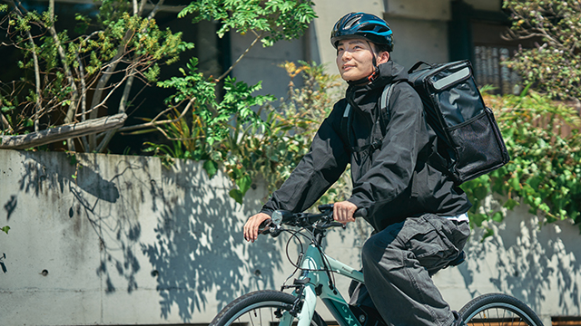 電動自転車でフードデリバリーをする若い男性